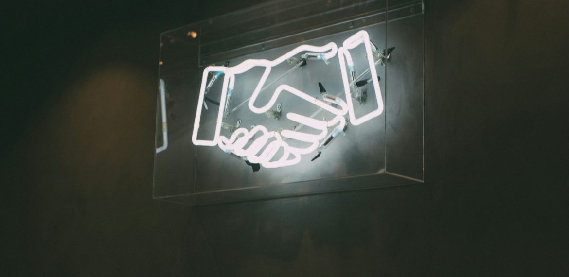 Afbeelding van een neon-billboard van twee handen die worden geschud